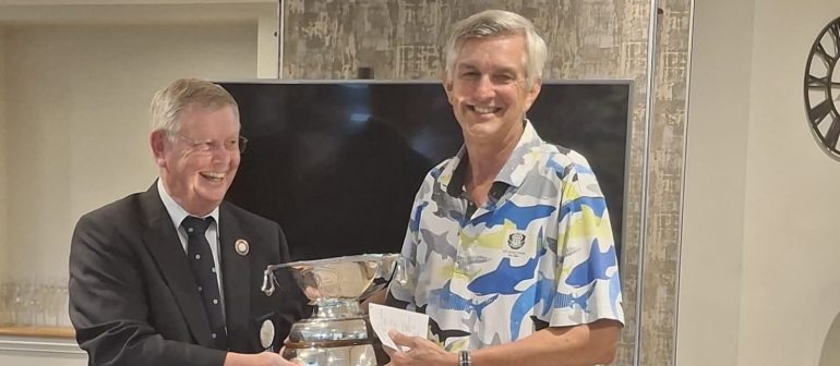 Gary Catt (right) receiving the trophy from YUGC president Bruce Light